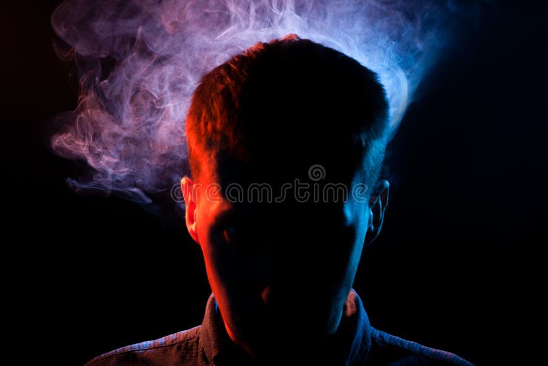 La cara del hombre se oculta en las sombras en un negro aisladas detrás foto de archivo La cara del hombre se oculta en las sombras en un negro aisladas detrás foto de archivo