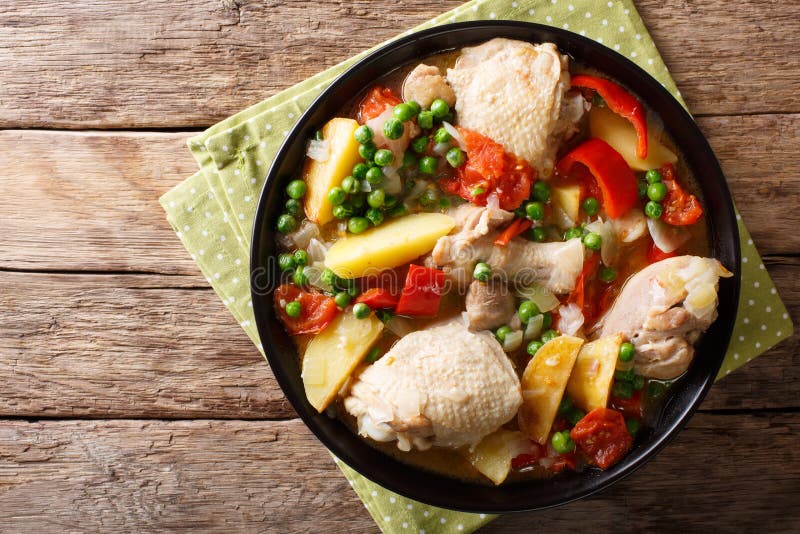 La carne del pollo guisó con las verduras y condimenta el primer en un arco. La carne del pollo guisó con las verduras y condimenta el primer en un cuenco en la tabla Visión superior horizontal desde arriba