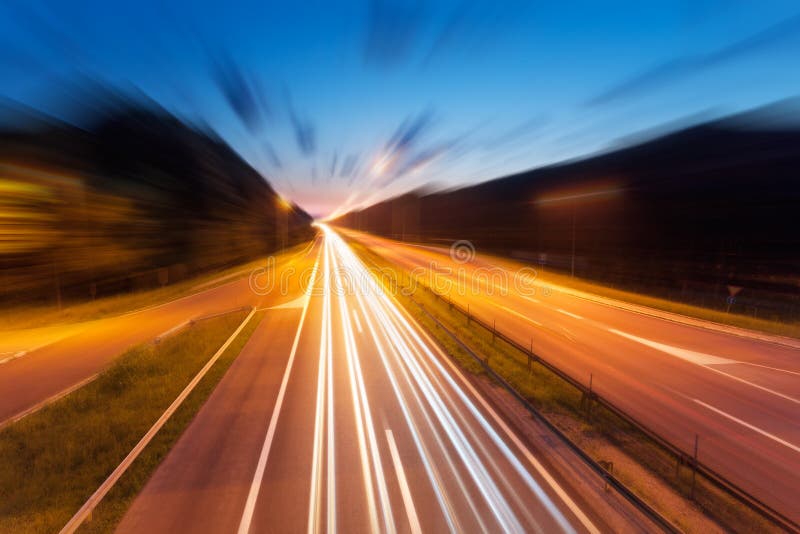 La carretera con la luz se arrastra en la oscuridad en el movimiento borroso foto de archivo La carretera con la luz se arrastra en la oscuridad en el movimiento borroso foto de archivo