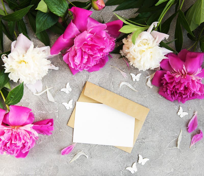 La carta dell'invito, la busta del mestiere e la peonia rosa fiorisce immagine stock La carta dell'invito, la busta del mestiere e la peonia rosa fiorisce immagine stock