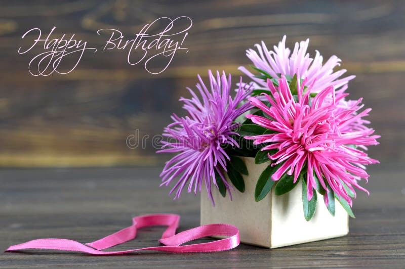 La carte de joyeux anniversaire avec des fleurs a arrangé dans le boîte-cadeau
