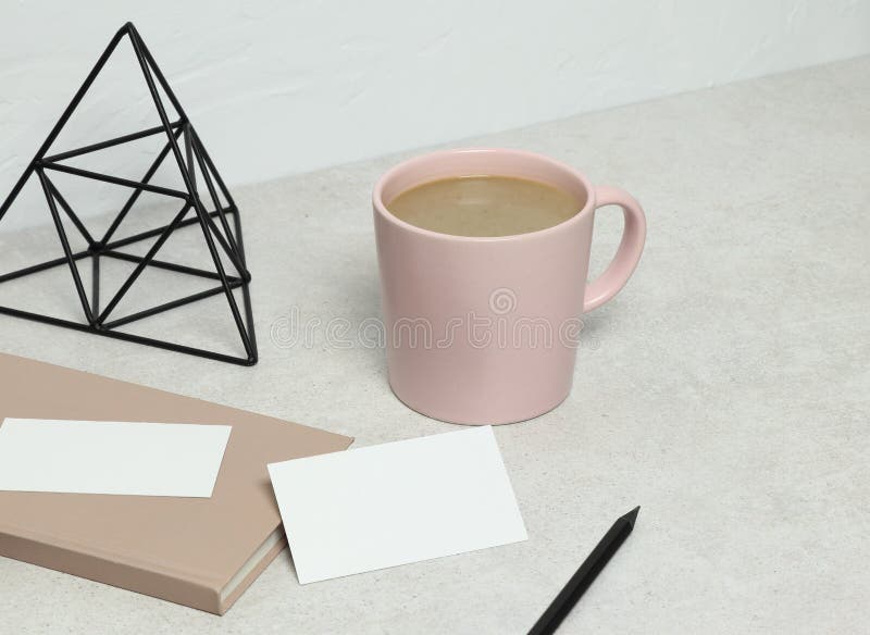 La carte de visite professionnelle de visite de maquette sur le granit avec le livre, le crayon et la statuette roses, tasse de c images stock La carte de visite professionnelle de visite de maquette sur le granit avec le livre, le crayon et la statuette roses, tasse de c images stock