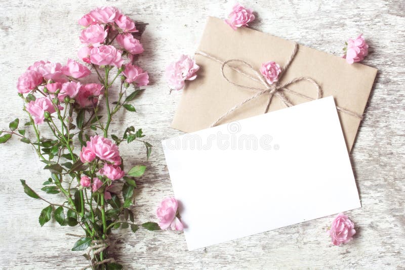 La cartolina d'auguri bianca in bianco con la rosa di rosa fiorisce il mazzo fotografia stock La cartolina d'auguri bianca in bianco con la rosa di rosa fiorisce il mazzo fotografia stock