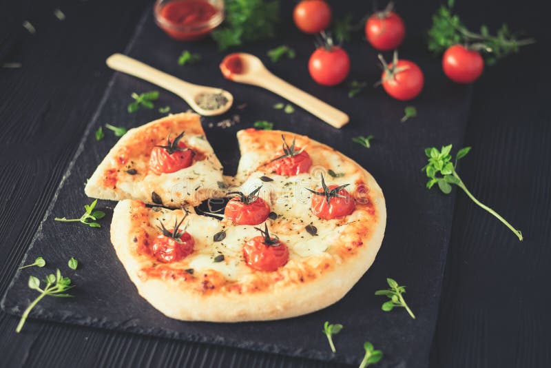 La casa di Margherita ha prodotto la pizza sulla tavola scura fotografie stock libere da diritti La casa di Margherita ha prodotto la pizza sulla tavola scura fotografie stock libere da diritti