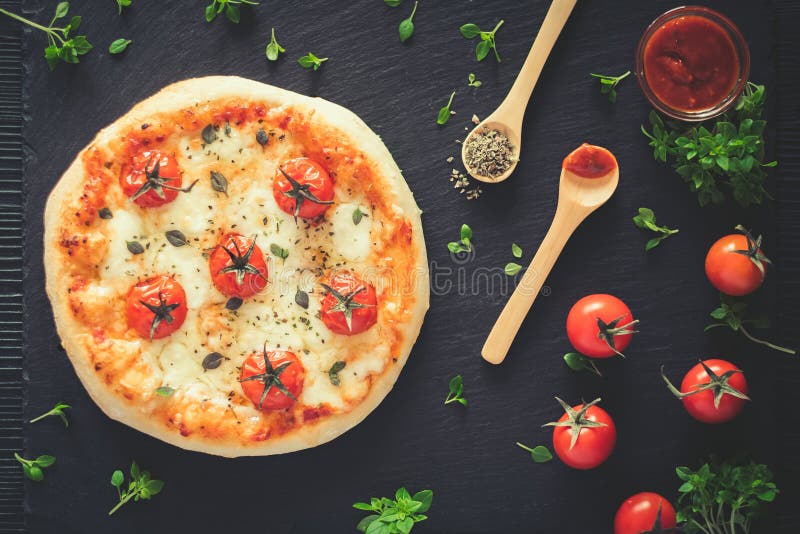 La casa di Margherita ha prodotto la pizza Vista superiore sulla tavola scura fotografia stock libera da diritti La casa di Margherita ha prodotto la pizza Vista superiore sulla tavola scura fotografia stock libera da diritti