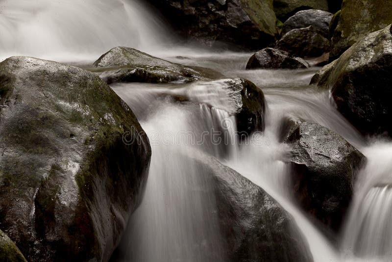 La cascada cae sobre el río viejo del ciruelo con las rocas