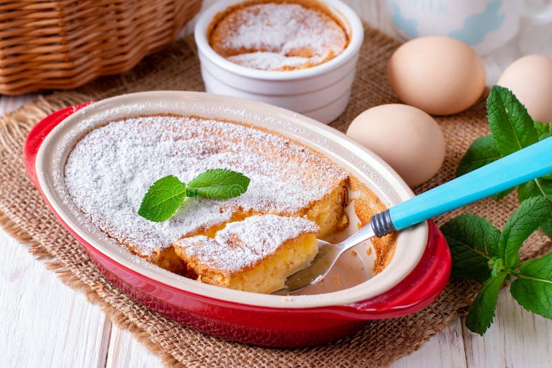La casseruola, il budino, la torta di formaggio, la crostata, la torta o la mousse casalinga in piatto bollente ovale sta sulla t immagini stock libere da diritti La casseruola, il budino, la torta di formaggio, la crostata, la torta o la mousse casalinga in piatto bollente ovale sta sulla t immagini stock libere da diritti