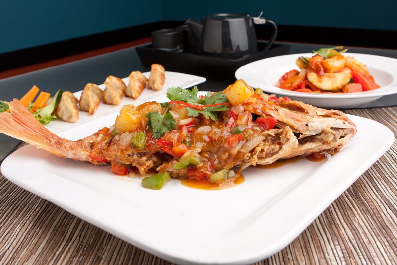 Freshly prepared Thai style whole fish red snapper dinner with sweet and sour shrimp and pan fried gyoza dumplings appetizer. Freshly prepared Thai style whole fish red snapper dinner with sweet and sour shrimp and pan fried gyoza dumplings appetizer.