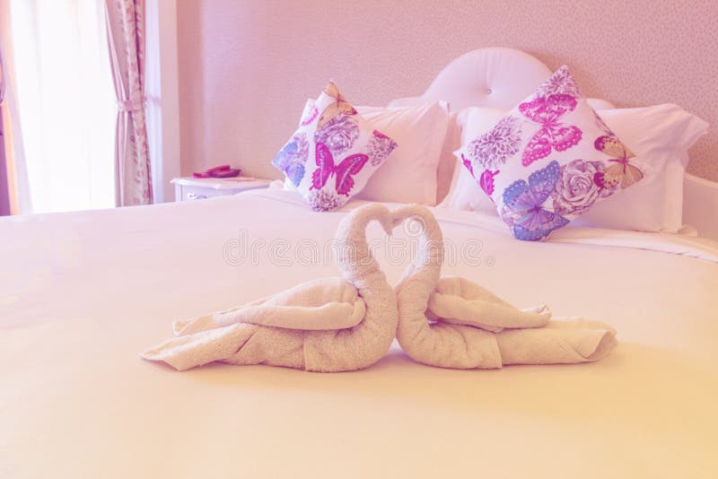 La chambre à coucher rose avec la serviette pliée dans la forme de cygne sur le lit se préparent à photo stock La chambre à coucher rose avec la serviette pliée dans la forme de cygne sur le lit se préparent à photo stock