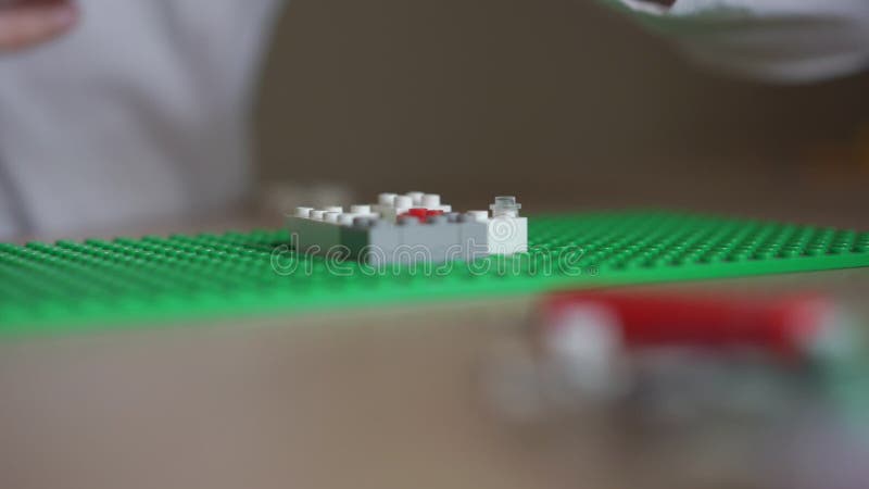 La chemise blanche joue avec la construction de lego vue rapprochée banque de vidéos