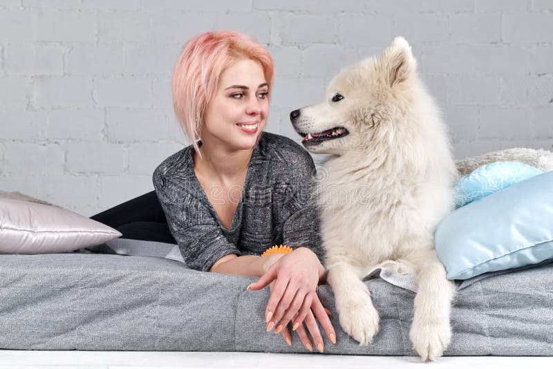 La chica joven bonita mira en los ojos de su mejor amigo el perro foto de archivo La chica joven bonita mira en los ojos de su mejor amigo el perro foto de archivo