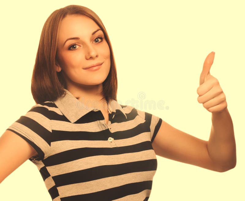 La chica joven feliz de la mujer del retrato muestra los pulgares del signo positivo sí, foto de archivo La chica joven feliz de la mujer del retrato muestra los pulgares del signo positivo sí, foto de archivo