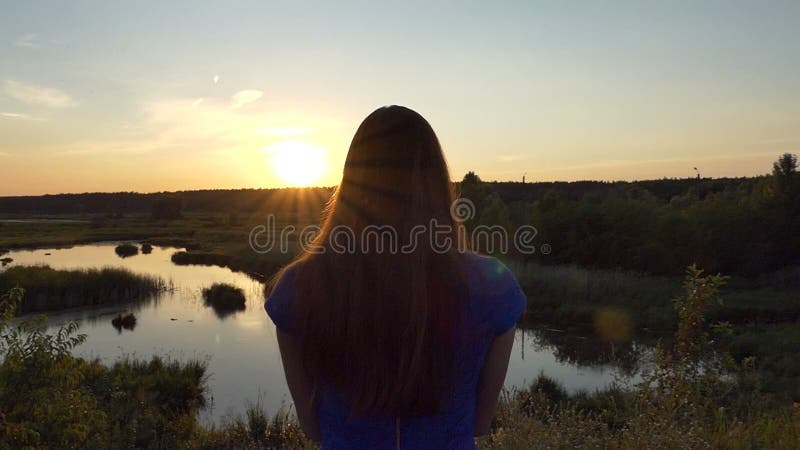 La chica joven hace la foto de la puesta del sol hermosa - cámara lenta
