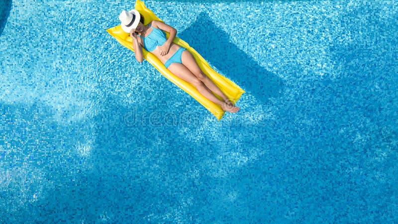 La chica joven hermosa que se relaja en la piscina, nadadas en el colch?n inflable y se divierte en agua el vacaciones de familia fotografía de archivo libre de regalías La chica joven hermosa que se relaja en la piscina, nadadas en el colch?n inflable y se divierte en agua el vacaciones de familia fotografía de archivo libre de regalías