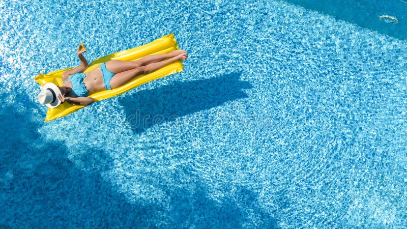La chica joven hermosa que se relaja en la piscina, nadadas en el colch?n inflable y se divierte en agua el vacaciones de familia fotos de archivo La chica joven hermosa que se relaja en la piscina, nadadas en el colch?n inflable y se divierte en agua el vacaciones de familia fotos de archivo