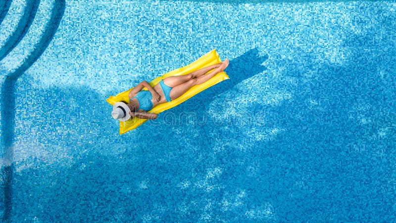 La chica joven hermosa que se relaja en la piscina, nadadas en el colchón inflable y se divierte en agua el vacaciones de familia imagen de archivo La chica joven hermosa que se relaja en la piscina, nadadas en el colchón inflable y se divierte en agua el vacaciones de familia imagen de archivo
