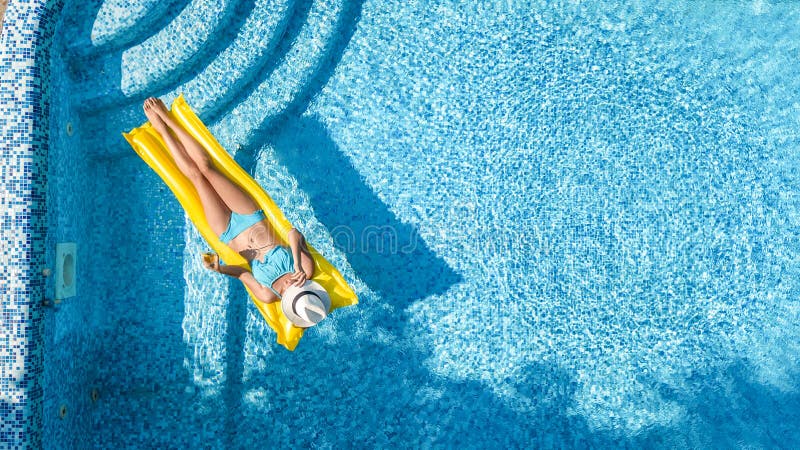 La chica joven hermosa que se relaja en la piscina, nadadas en el colchón inflable y se divierte en agua el vacaciones de familia fotografía de archivo libre de regalías La chica joven hermosa que se relaja en la piscina, nadadas en el colchón inflable y se divierte en agua el vacaciones de familia fotografía de archivo libre de regalías