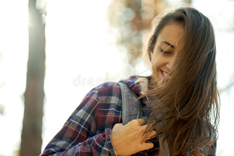 La chiusura mette in evidenza il ritratto di una donna positiva nella foresta con luci di sfondo immagini stock libere da diritti