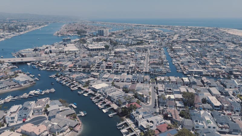 La ciudad costera muestra varias casas a lo largo de la orilla curva y barcos en el puerto deportivo. almacen de metraje de vídeo
