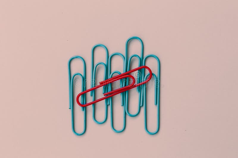 La clip rossa della carta colorata con una differenza sul blu taglia altro MI fotografie stock La clip rossa della carta colorata con una differenza sul blu taglia altro MI fotografie stock