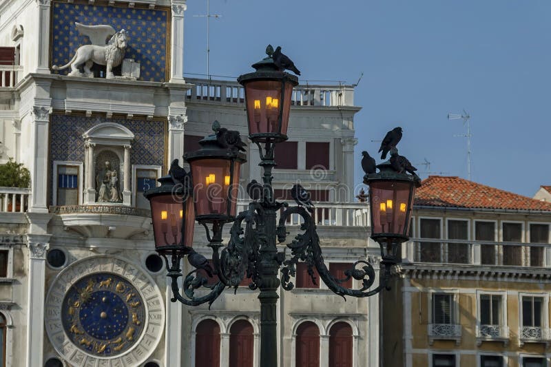 La colonna con il leone di St Mark, simbolo torre di orologio imperiale dello zodiaco, di Venezia e madre di Dio nel ` s di San M fotografie stock La colonna con il leone di St Mark, simbolo torre di orologio imperiale dello zodiaco, di Venezia e madre di Dio nel ` s di San M fotografie stock