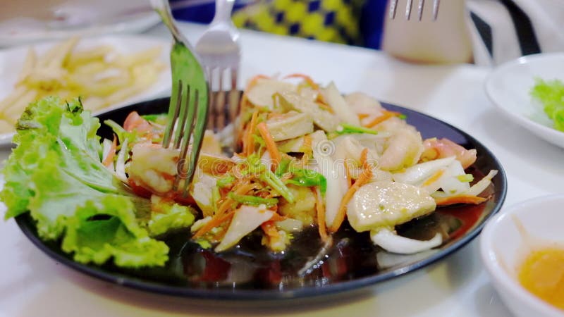 La comida picante de la ensalada con la gente goza el comer junta