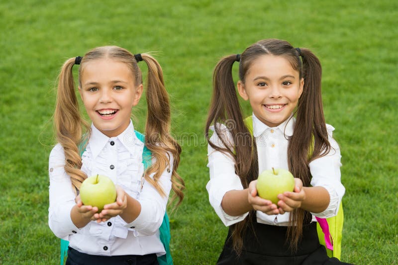 La connaissance, c'est savoir que la pomme est un fruit. les filles heureuses tiennent des pommes sur l'herbe verte. pommes vertes photographie stock