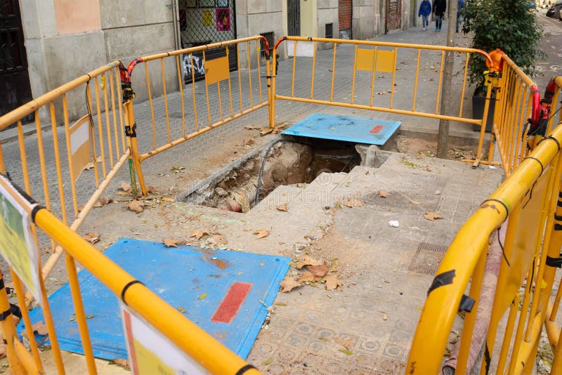 La construction de rue travail le trou dans la barrière jaune moulue photographie stock libre de droits La construction de rue travail le trou dans la barrière jaune moulue photographie stock libre de droits