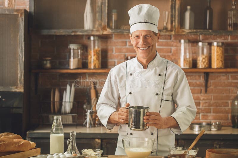 La cottura del cuoco unico del forno cuoce nel professionista della cucina fotografia stock La cottura del cuoco unico del forno cuoce nel professionista della cucina fotografia stock