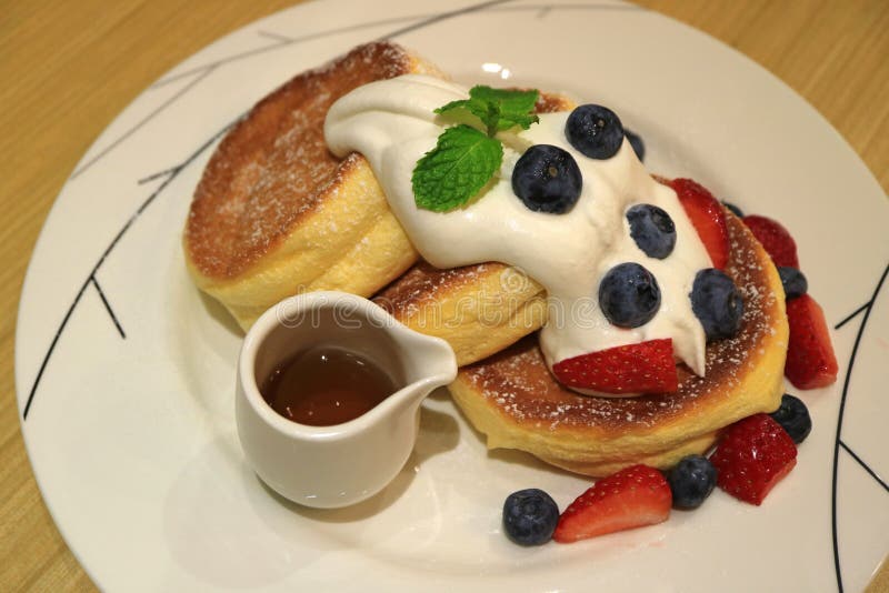 La crepe deliciosa del soplo con el jarabe de arce, la crema azotada fresca y las bayas de la mezcla sirvió en la placa blanca fotos de archivo libres de regalías La crepe deliciosa del soplo con el jarabe de arce, la crema azotada fresca y las bayas de la mezcla sirvió en la placa blanca fotos de archivo libres de regalías