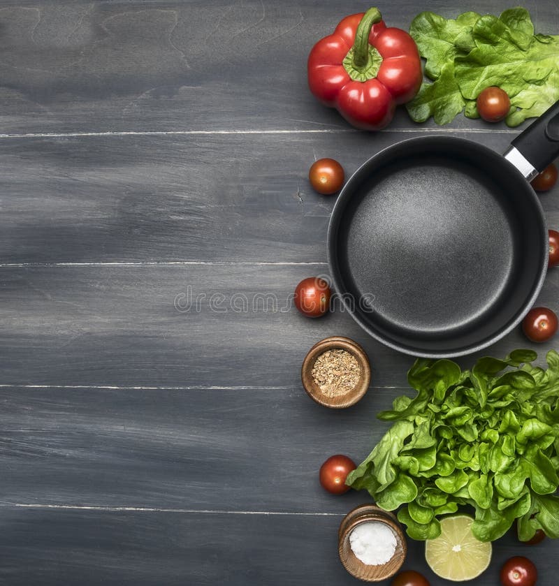 La cuisson d'un dîner végétarien, les paprikas rouges et jaunes, salade, cuillère en bois, tomates-cerises, condiments, chaux, no photo libre de droits La cuisson d'un dîner végétarien, les paprikas rouges et jaunes, salade, cuillère en bois, tomates-cerises, condiments, chaux, no photo libre de droits