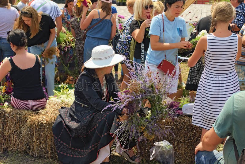 La dame a juste fini de faire sa guirlande Les gens tissent des guirlandes des fleurs sauvages Concept d'?t? image stock La dame a juste fini de faire sa guirlande Les gens tissent des guirlandes des fleurs sauvages Concept d'?t? image stock