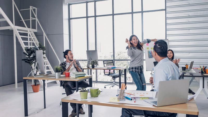 La danse créative de concepteur dans le bureau, se répandent bon nouveau pour favoriser au directeur félicitation de collègue à l photographie stock La danse créative de concepteur dans le bureau, se répandent bon nouveau pour favoriser au directeur félicitation de collègue à l photographie stock
