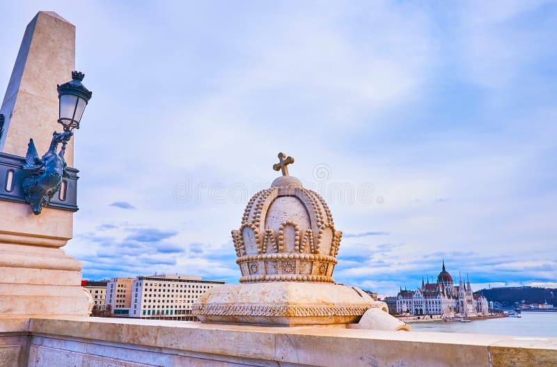 The vintage streetlights atop the column and the sculpture of the Holy Crown of Hungary on the  Margaret Bridge in Budapest, Hungary. The vintage streetlights atop the column and the sculpture of the Holy Crown of Hungary on the  Margaret Bridge in Budapest, Hungary