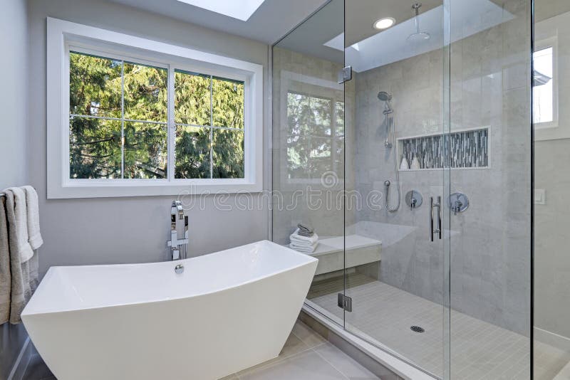 La doccia delle persone senza appuntamento di vetro in un bagno di nuova casa di lusso