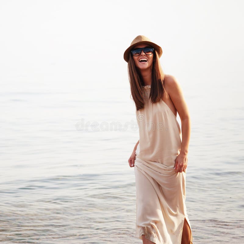 La donna allegra sorridente sveglia passa le vacanze estive su una spiaggia del mare fotografie stock La donna allegra sorridente sveglia passa le vacanze estive su una spiaggia del mare fotografie stock