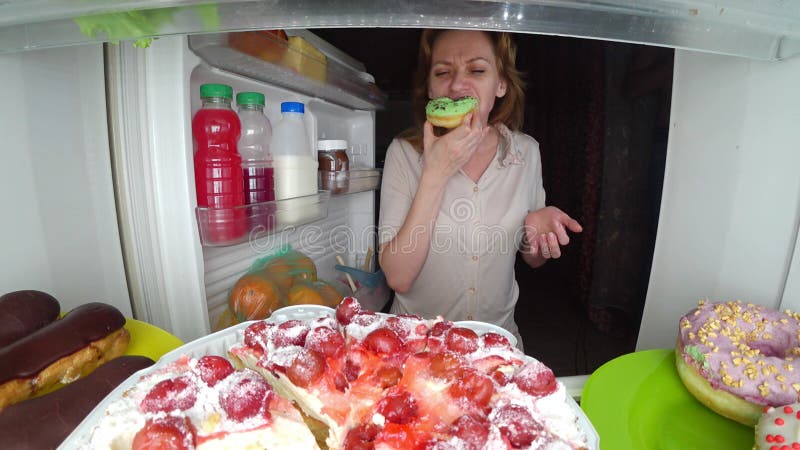 La donna apre il frigorifero alla notte Fame di notte gola di dieta