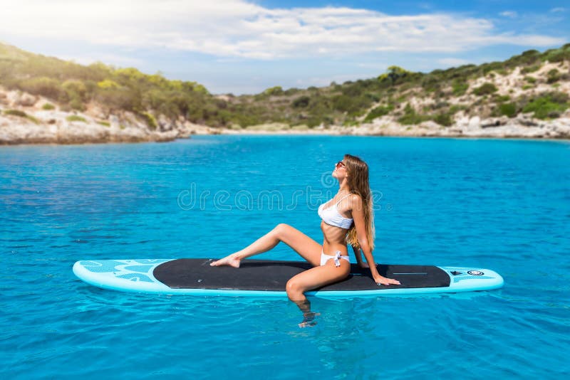 La donna bionda gode di un giorno di estate caldo su un surf immagine stock La donna bionda gode di un giorno di estate caldo su un surf immagine stock