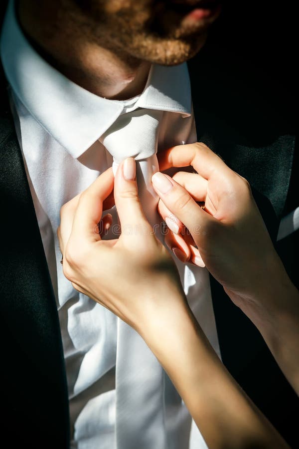 La donna corregge il legame degli uomini fotografia stock La donna corregge il legame degli uomini fotografia stock