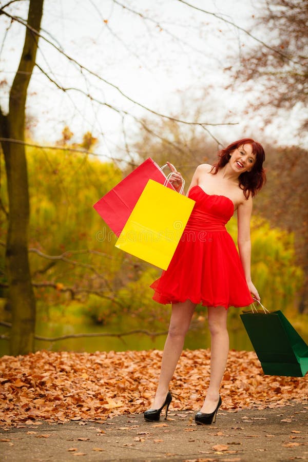 La donna del cliente di autunno con la vendita insacca all'aperto in parco immagini stock libere da diritti La donna del cliente di autunno con la vendita insacca all'aperto in parco immagini stock libere da diritti