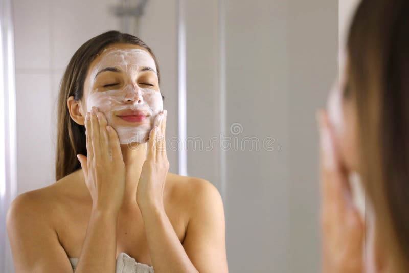 La donna della pelle che si lava la faccia si pulisce la pelle di sapone che si strofina Esfoliamento del lavaggio del viso lavar