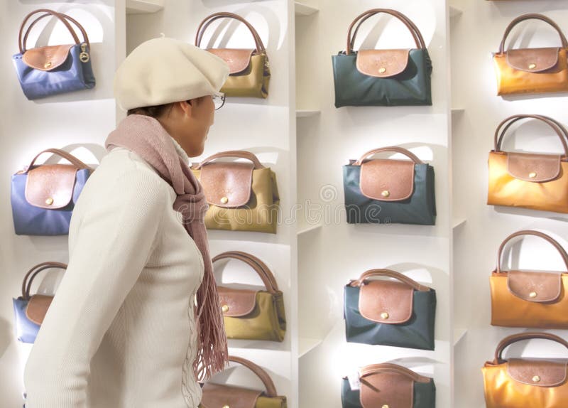 La donna di acquisto sceglie la borsa di signora in stor immagine stock La donna di acquisto sceglie la borsa di signora in stor immagine stock
