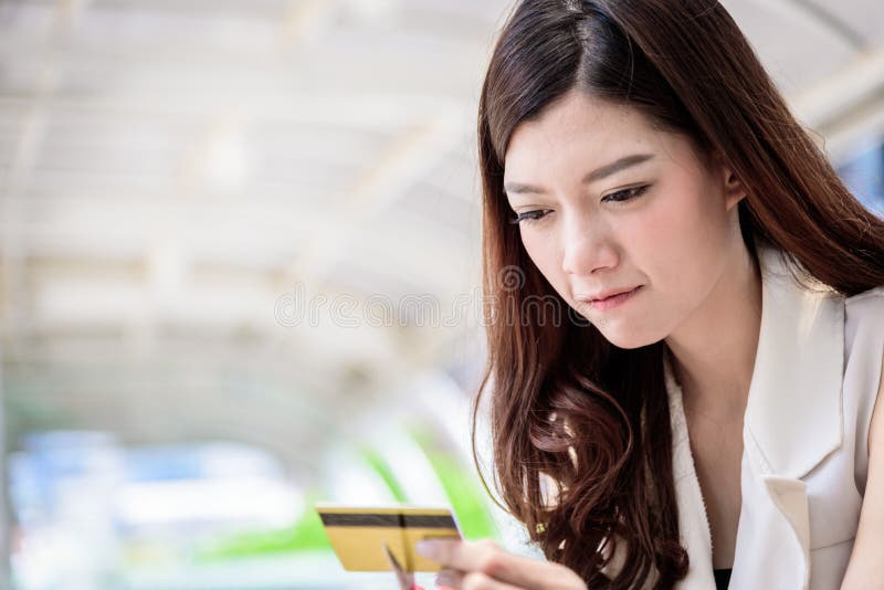 La donna di affari asiatica ha distruggere una carta di credito con Sc rosso fotografia stock La donna di affari asiatica ha distruggere una carta di credito con Sc rosso fotografia stock