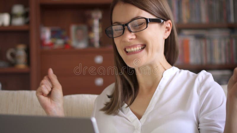 La donna di affari che per mezzo del computer portatile a casa, buone notizie di ricezione femminili professionali ha eccitato so