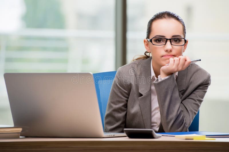 La donna di affari triste che lavora al suo scrittorio fotografia stock libera da diritti La donna di affari triste che lavora al suo scrittorio fotografia stock libera da diritti