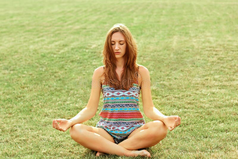 La donna di bellezza pratica l'yoga e medita nella posizione di loto nel parco meditazione Stile di vita attivo Conce di yoga e s fotografia stock La donna di bellezza pratica l'yoga e medita nella posizione di loto nel parco meditazione Stile di vita attivo Conce di yoga e s fotografia stock