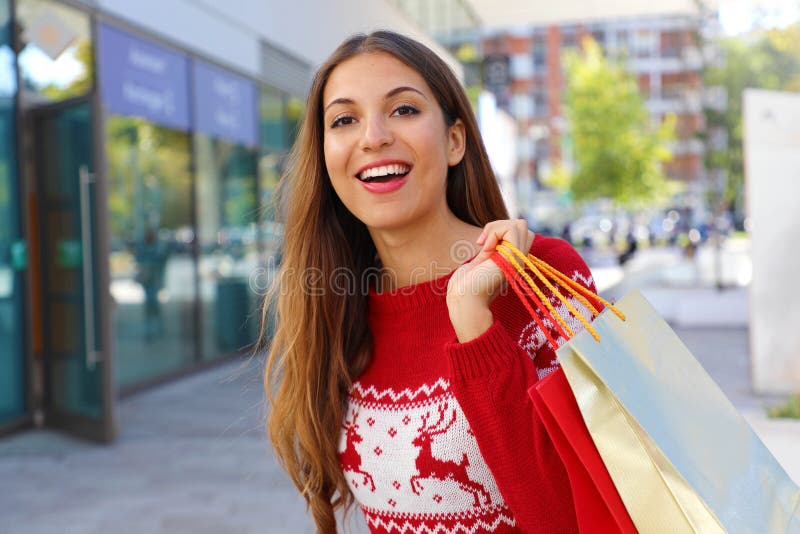 La donna di Natale in strada che porta regali di natale nelle borse della spesa immagine stock La donna di Natale in strada che porta regali di natale nelle borse della spesa immagine stock