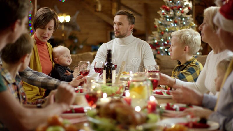 La donna dà il regalo di Natale al suo marito durante la cena di natale