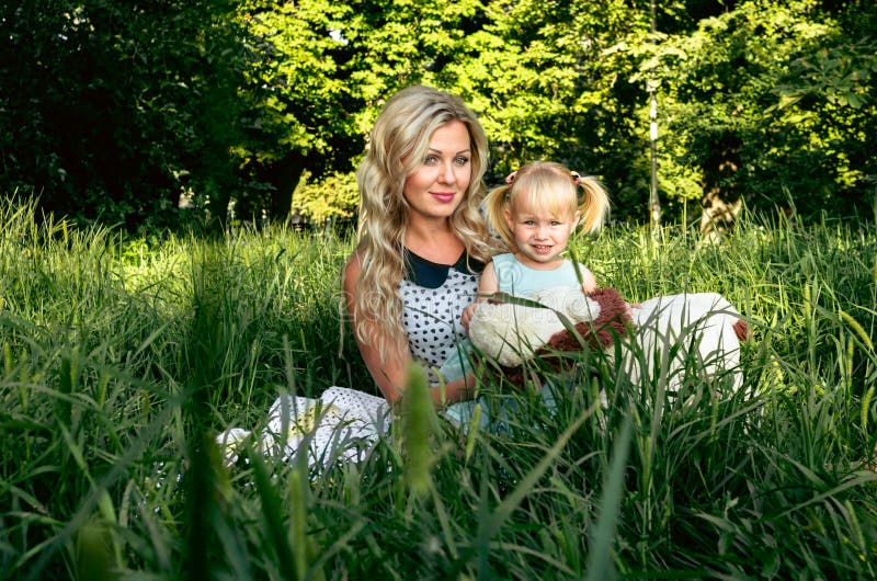 La donna ed il bambino felici nella molla di fioritura fanno il giardinaggio Concetto di festa di giorno di madri o del giorno de immagine stock La donna ed il bambino felici nella molla di fioritura fanno il giardinaggio Concetto di festa di giorno di madri o del giorno de immagine stock