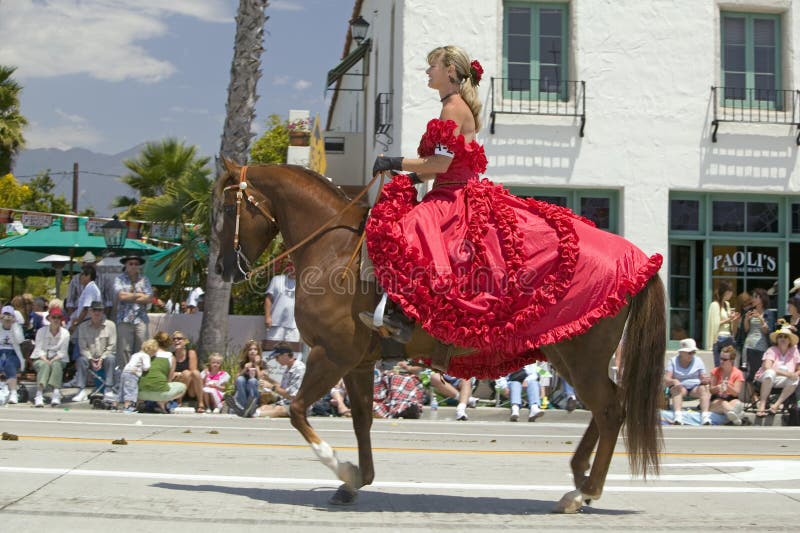 La donna graziosa con uno Spagnolo rosso si veste a cavallo durante la parata giù State Street, Santa Barbara, CA, il vecchio gio immagini stock La donna graziosa con uno Spagnolo rosso si veste a cavallo durante la parata giù State Street, Santa Barbara, CA, il vecchio gio immagini stock